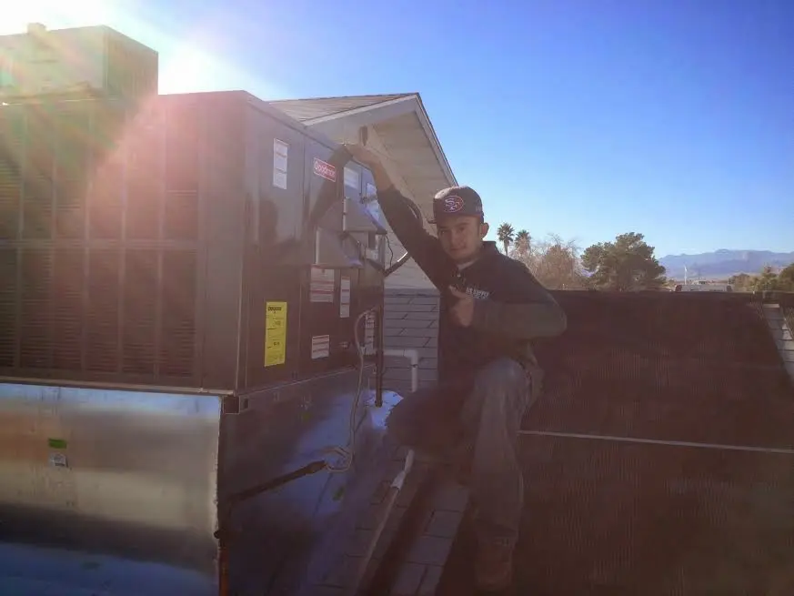 HVAC technician performing Heat Pump Repair on a rooftop unit in South Venice